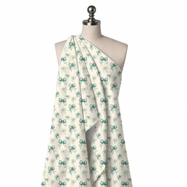 Draped on a mannequin: tonal all-over print of medium and small bows in etched teal green, design Design No_4435, Clothwala