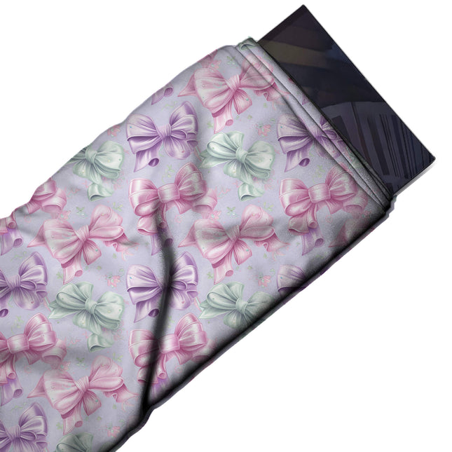 Flat fabric swatch: close-set all-over print of medium to large high-gloss satin-look bows, design Design No_4419, Clothwala